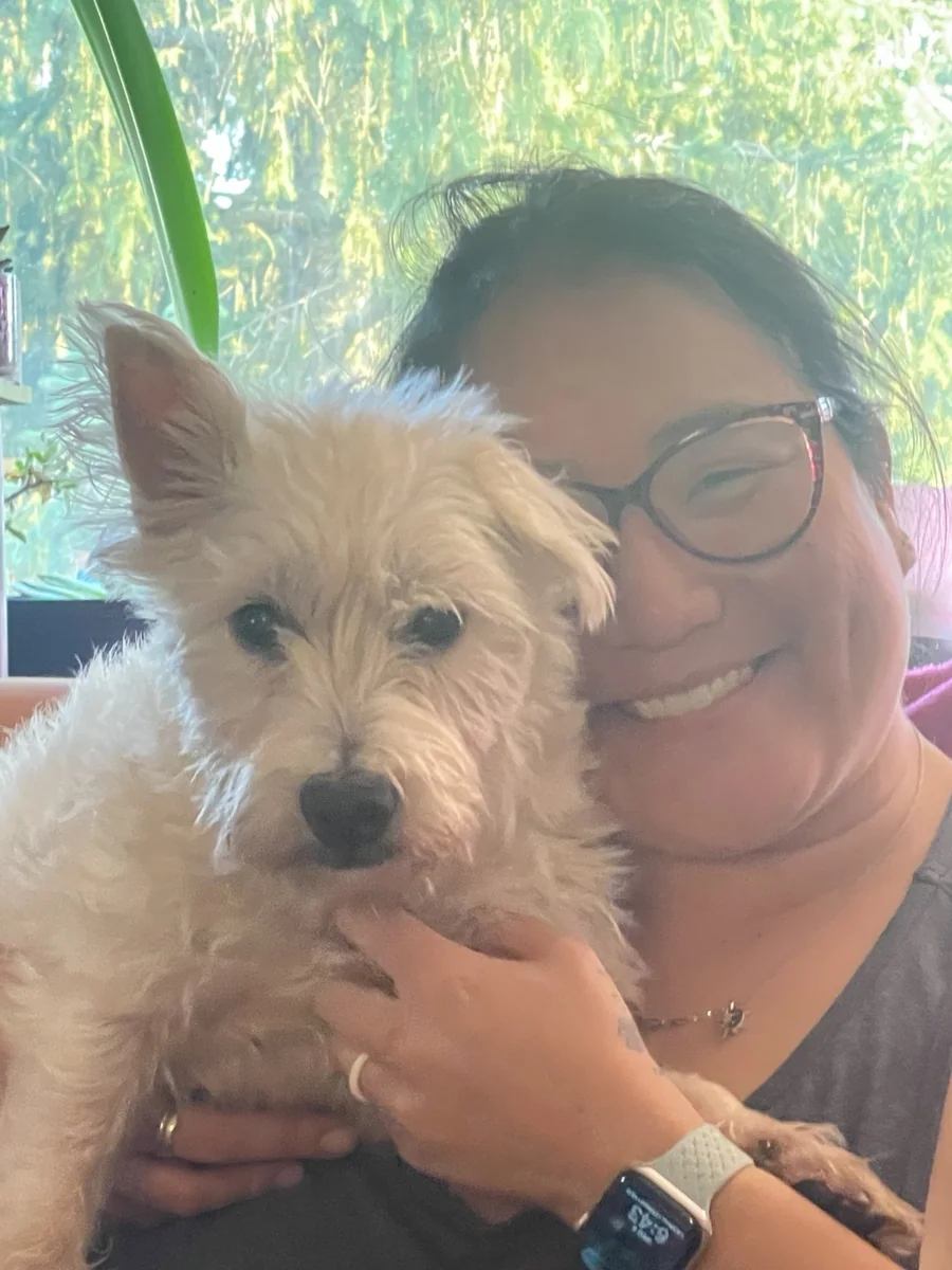 Amy smiling with a white dog